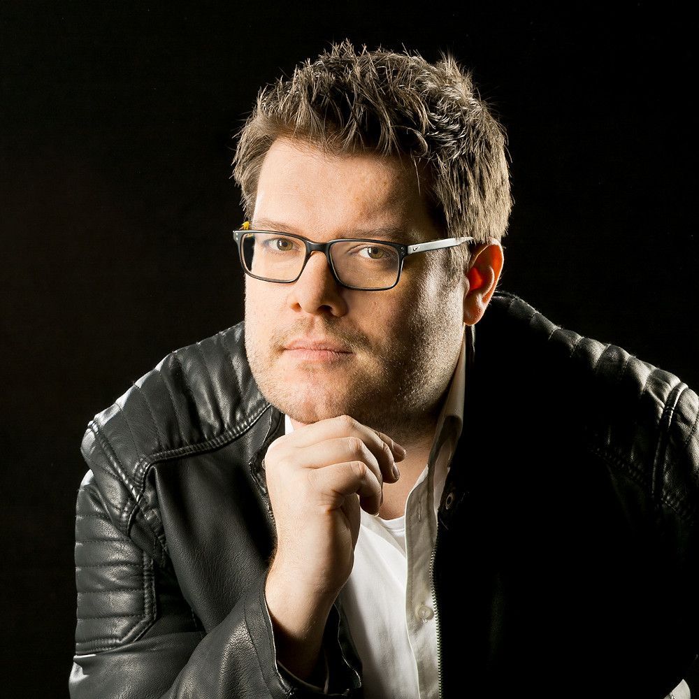Henning Leutz Porträt von Henning Leutz mit Brille und dunkler Lederjacke.