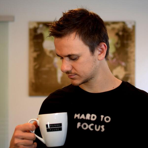 Porträt von Michael Danielczok mit einer Tasse in der Hand.