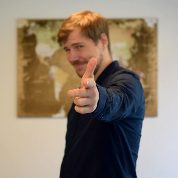 Patrick Müller lächelt im Büro in die Kamera.