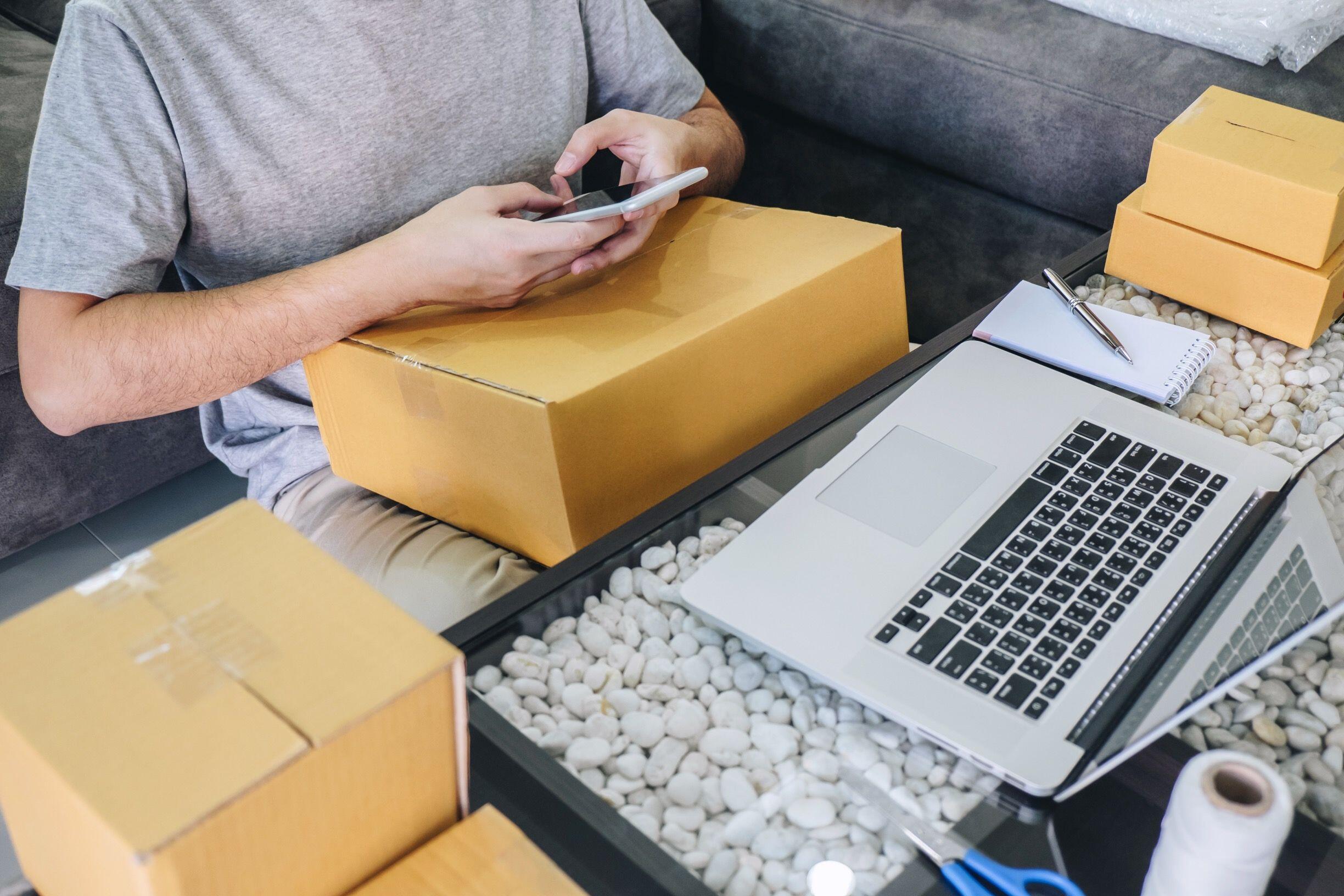 Mobiles Online-Business im Homeoffice Person arbeitet mit Smartphone und Laptop an Online-Business-Abläufen im Homeoffice