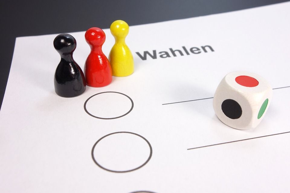 Spielfiguren und Würfel auf einem Wahlzettel als Anspielung auf „Mensch ärgere Dich nicht“.